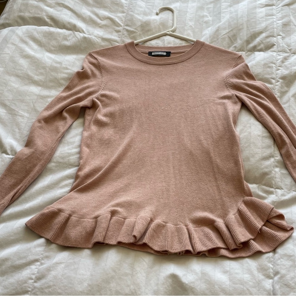 Pink long sleeved sweater with flair on bottom
